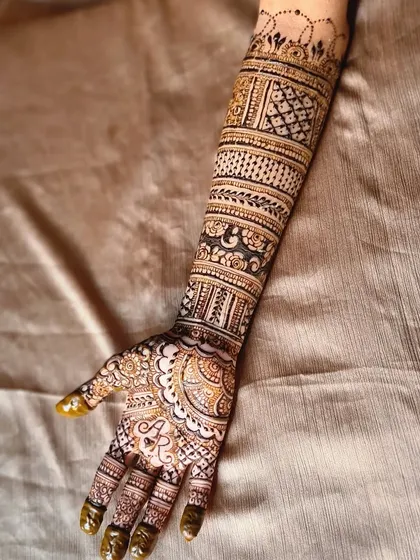 I love adding personal touches, like hiding the groom's initials within the bride's mehndi. Here, the letters 'AR' are woven into the detailed design on the palm, a sweet and secret tribute.