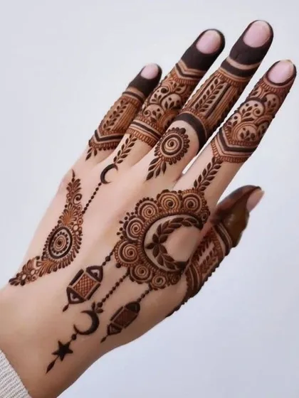 An elegant and modern Eid mehndi design. This style uses delicate crescents, stars, and lantern motifs, combined with fine jewelry-like patterns, to celebrate the spirit of Eid. It is light, beautiful, and perfect for the occasion.