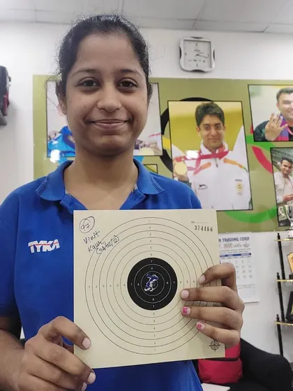 One of our dedicated students, Vineet Kaur, holding up her target card. Consistent practice is the key to improving scores.