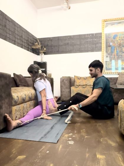 Using a strap is a key technique for safely working on splits. Here, it allows the student to maintain control while I provide gentle assistance.