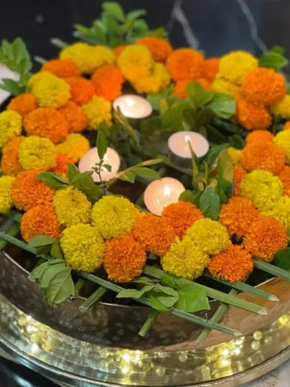 Here is one of my favorite ways to create a festive atmosphere. This traditional urli is filled with a vibrant arrangement of fresh marigolds and softly glowing candles, creating a warm and inviting centerpiece for any celebration.