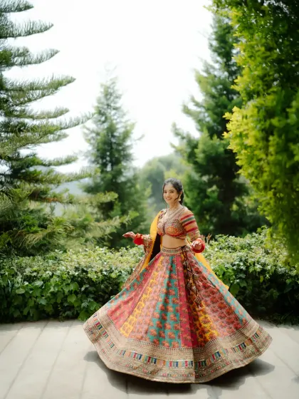 A classic twirl shot of the bride in her multi-colored Haldi lehenga. This captures the movement and vibrancy of her outfit perfectly.