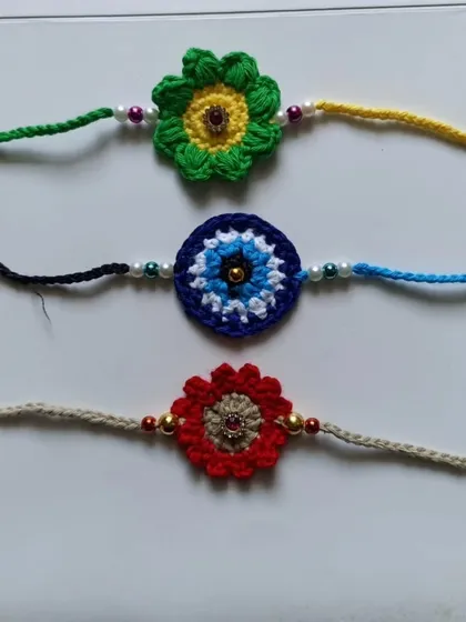 A trio of my popular rakhi designs. This set includes a sunflower, an evil eye for protection, and a classic red flower, each with unique detailing.