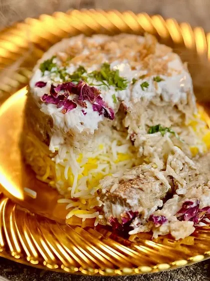 A beautifully layered Chicken Malai Biryani, showing the tender chicken, creamy sauce, and fragrant saffron rice. This dish is mild in spice but rich in flavor, making it a favorite for all ages.