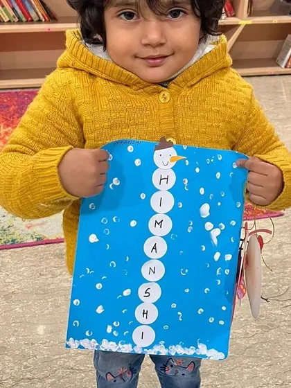 The proud smile of a child showing off their creation is the best reward. This little one made a beautiful snowman during our winter camp, learning about seasons while having creative fun.