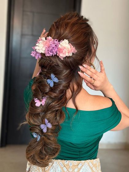 A textured Mehendi braid with beautiful butterfly and floral accessories. This whimsical and romantic style is perfect for a bride who wants something unique.