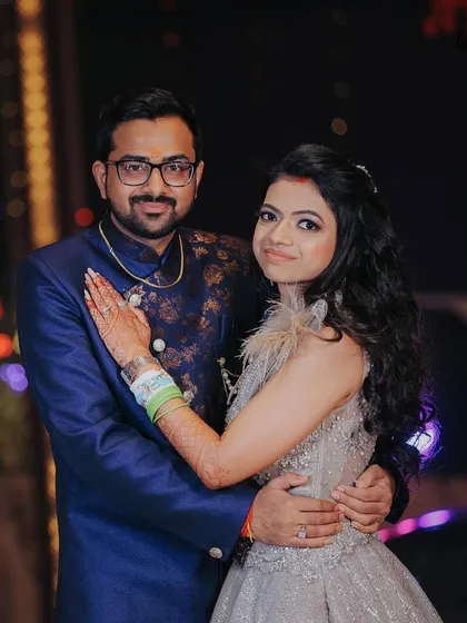 A classic portrait of the couple from their engagement night. Their coordinated outfits and happy smiles make for a perfect memory.