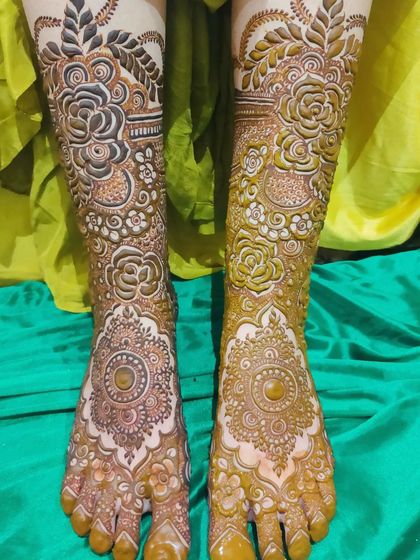 The process of creating a bridal foot design, showing one leg complete and the other ready for its art.