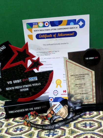 A collection of the trophies, medals, and certificates from the North India Powerlifting Championship. Each one tells a story of dedication.