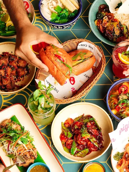 A vibrant flatlay of a Vietnamese meal, including banh mi sandwiches and pho.