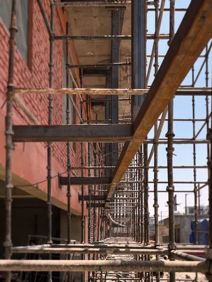 The intersecting geometries of a steel exoskeleton during construction. This raw, modular structure will eventually form the defining feature of the building's facade.
