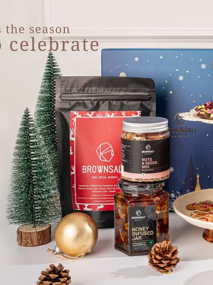 This image captures the cozy feeling of the season. Our Christmas hamper includes a honey-infused jar, a nuts and seeds mix, and our special granola, perfect for sharing and celebrating.