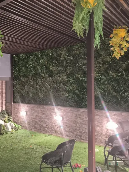 Another shot from the Paschim Vihar project, showing the installation of the artificial green wall panel against the stone texture.