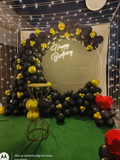 A clear shot of the birthday backdrop with the cake stand in front. The combination of the neon sign, balloons, and stand creates a complete setup for cake cutting ceremonies.