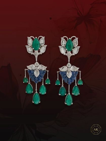 This pair of statement earrings features natural Zambian emeralds, diamonds, and ruby briolettes, elegantly accented by rose-cut diamonds.