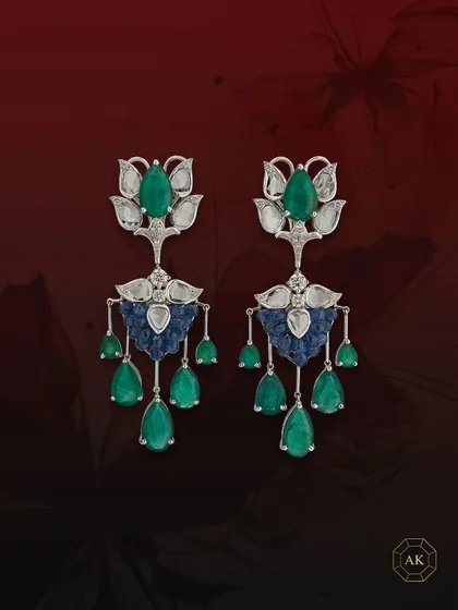 This pair of statement earrings features natural Zambian emeralds, diamonds, and ruby briolettes, elegantly accented by rose-cut diamonds.