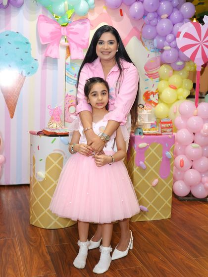 A mother and daughter share a hug in their Candyland wonderland. The colorful, sweet-themed decor provides a joyful and vibrant setting for family photos.