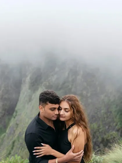 A quiet embrace amidst the fog-covered mountains of Munnar. This intimate portrait focuses on the feeling of being in your own world together, with the dramatic landscape fading into a soft, ethereal background.