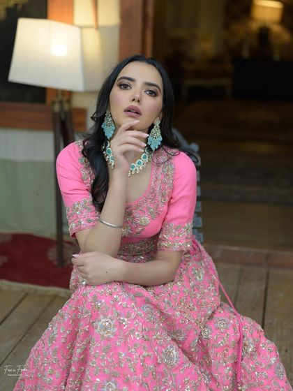 A full shot of this stunning pink lehenga. The makeup is kept fresh and pretty to balance the vibrant color of the outfit.
