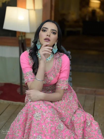 A beautiful portrait in a vibrant pink lehenga. The makeup is kept soft and neutral to let the outfit shine.