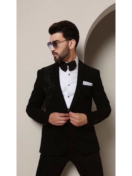 The Galaxy tuxedo, designed for the modern man. The asymmetric cosmic-inspired beadwork on the shoulder adds a touch of futuristic elegance to the classic black-tie silhouette.