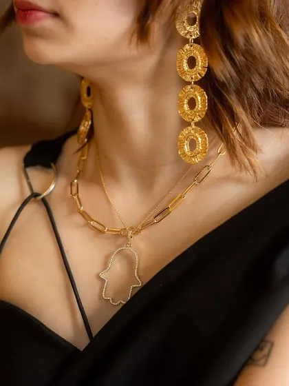 Statement earrings and a layered necklace, because ordinary is never an option. This look features my jumbo hamsa necklace and a chunky gold chain.