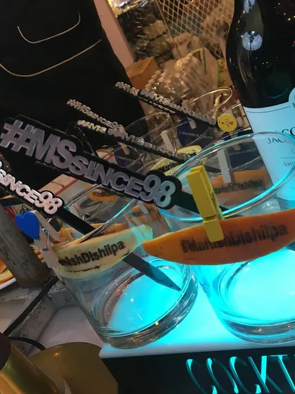 Custom stirrers and garnishes featuring the '#MrandMrsSince98' and '#Hiteshdishilpa' hashtags.