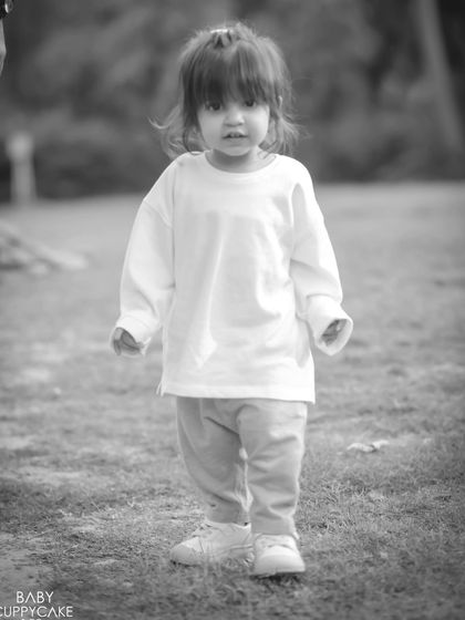 A toddler exploring an outdoor park in a classic black and white photo, giving it a timeless, nostalgic feel.