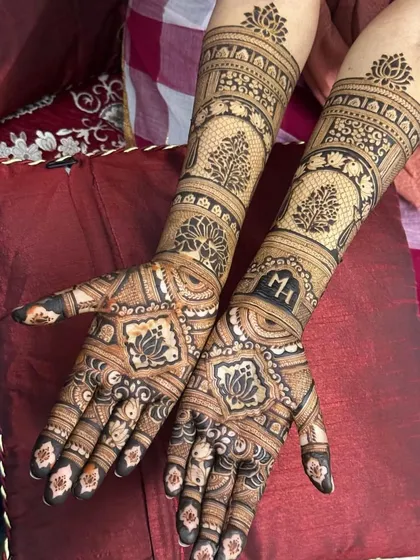 A beautiful design featuring the tree of life and lotus motifs. The couple's initials, "MH", are subtly integrated into the pattern on the back of the hands.