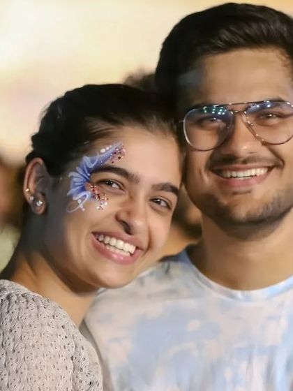 A happy couple enjoying an event, with the woman wearing a delicate blue glitter butterfly design.