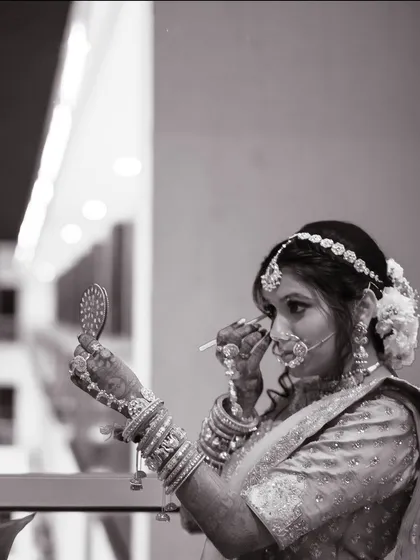 A black and white shot of the bride getting ready, capturing a quiet, behind-the-scenes moment of preparation.