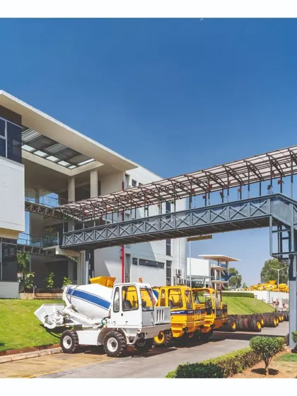 A steel truss bridge connects two buildings on the campus, allowing for efficient circulation. The exposed structure is an example of material honesty and serves as a key element in the industrial aesthetic of the factory complex.