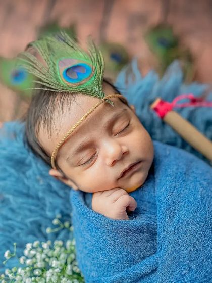 A peaceful close-up focusing on the baby's face, showcasing the tiny details of the theme like the feather and headband.