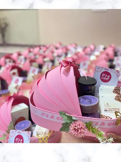 Announcing a baby girl in the sweetest way. Our pink cradle hamper is adorned with flowers and ribbons and filled with curated treats to celebrate the occasion.