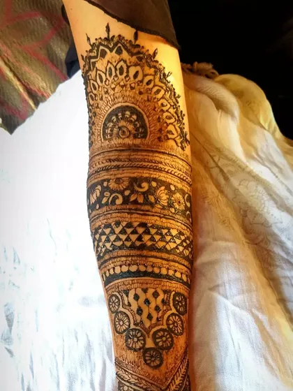 This image shows the upper arm portion of a bridal design. It features a large semi-circular mandala, a common element that looks beautiful with sleeveless blouses.
