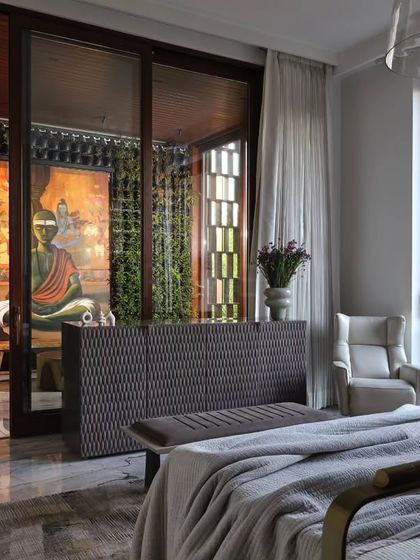This bedroom opens up to a tranquil balcony with a view of a Buddha statue and a vertical garden. The design ensures that even the most private spaces in the home offer a connection to spirituality and nature.
