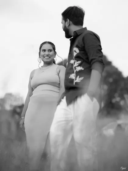 A soft, dreamy black and white portrait of Prem and Jinal. The focus is on her joyful expression as she looks at him, capturing a candid moment of happiness during their outdoor pre-wedding shoot.