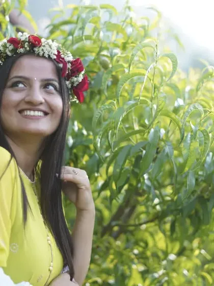 A bright, happy outdoor portrait of the bride-to-be. The natural greenery of the orchard provides a fresh and beautiful backdrop for this mehendi photoshoot.