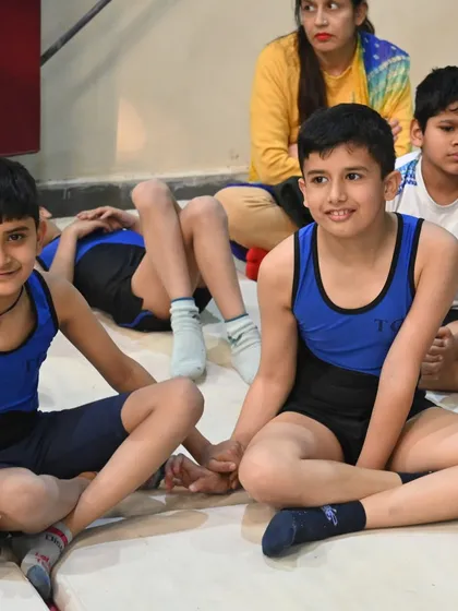 A candid moment between two young gymnasts, sharing a conversation during a break.