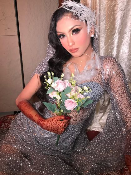 This pose captures the dreamy essence of the look, with the bride holding a bouquet of soft pink and white flowers that complement her makeup.