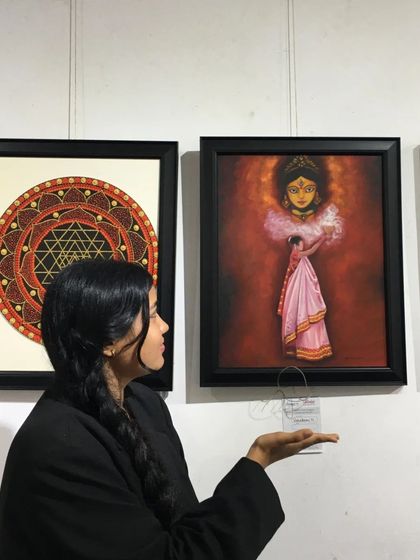 An artist proudly presenting her painting "The Worshipper of Durga" at the Chitrakar exhibition.