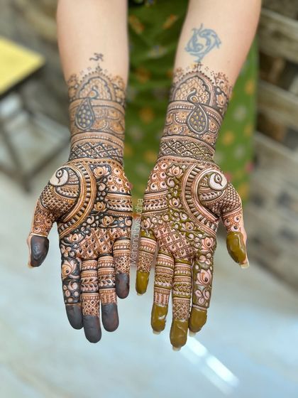 A beautiful, dense design for a client, featuring large peacock motifs on the palms and intricate patterns on the forearms.