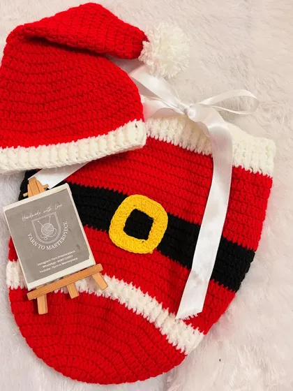 Get your newborn ready for their first holiday season with this adorable Santa-themed cocoon and beanie set. It’s made from soft, warm yarn, making it a cozy and festive prop for Christmas photoshoots.