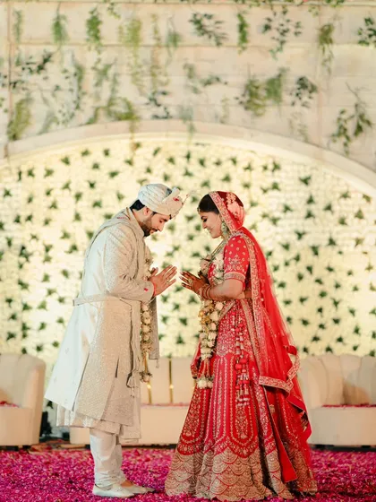 A moment of mutual respect and love. The couple greets each other with a 'namaste' at their beautiful floral-themed wedding ceremony.