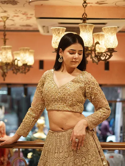 Turn heads in this gold embellished lehenga, paired with a dazzling sequin work blouse.