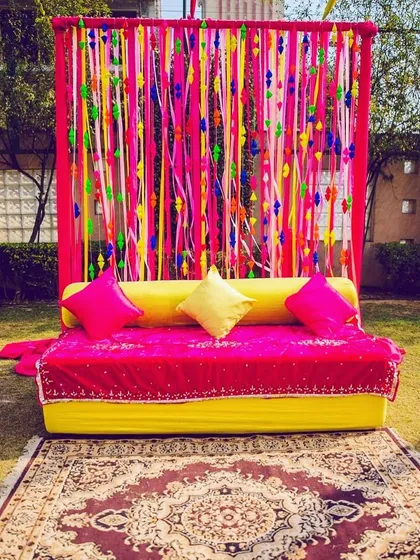 Another view of the colorful ribbon backdrop for a Mehndi ceremony. It's a simple idea that has a big visual impact, perfect for outdoor daytime events.
