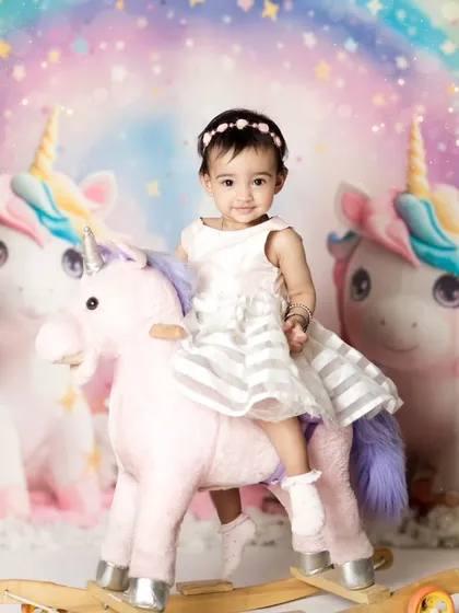 For the little girl who dreams of magic, we created this unicorn-themed first birthday shoot. She looks so happy on her rocking unicorn against the pastel rainbow backdrop. We have many creative themes for your child's special day.