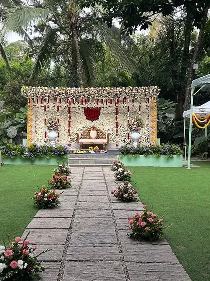 This image shows the scale of our outdoor wedding setups. You can see the main floral mandap, guest seating arrangement on the lawn, and temporary tents for logistics, demonstrating how we manage the entire venue decoration.