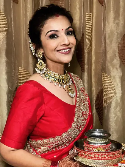 A beautiful traditional look for Karva Chauth, featuring a classic bun adorned with fresh gajra. It's the perfect complement to a red sari.