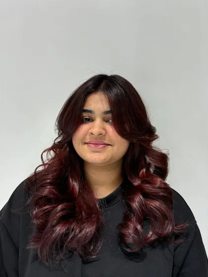 The auburn color looks rich and vibrant, adding warmth and personality to her overall style.